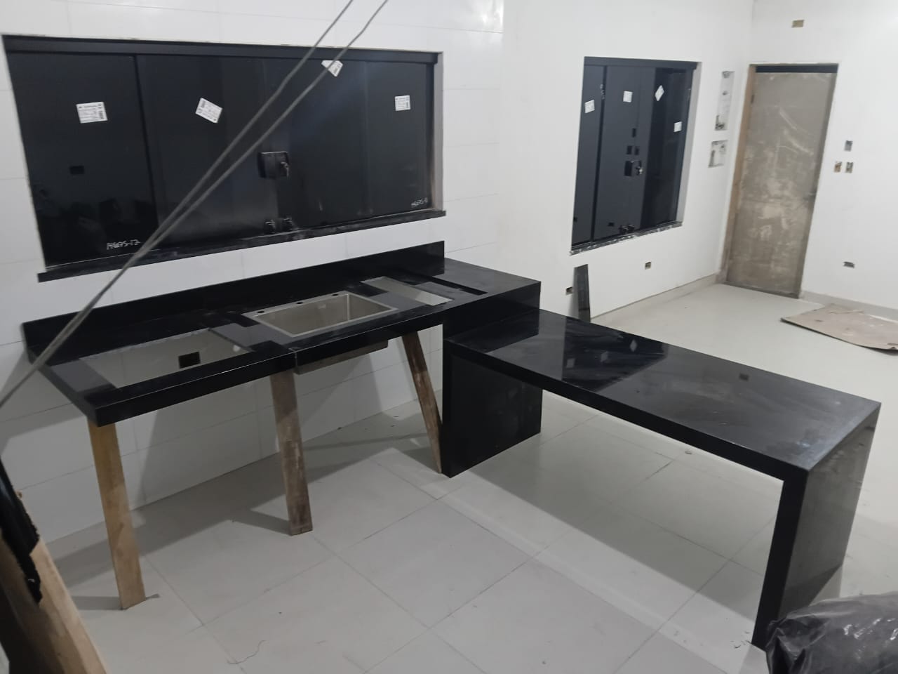Bancadas de cozinha em pedra preta com cuba e mesa em L